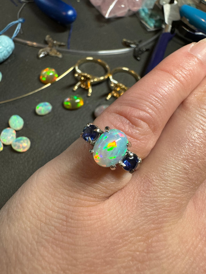 14K white gold custom ring with opal center and blue sapphire accents