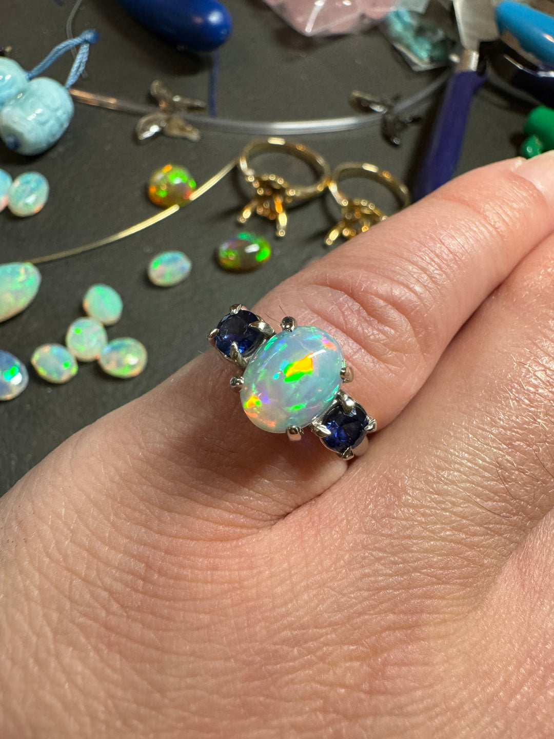 Custom opal ring with blue sapphires, profile view showing setting detail