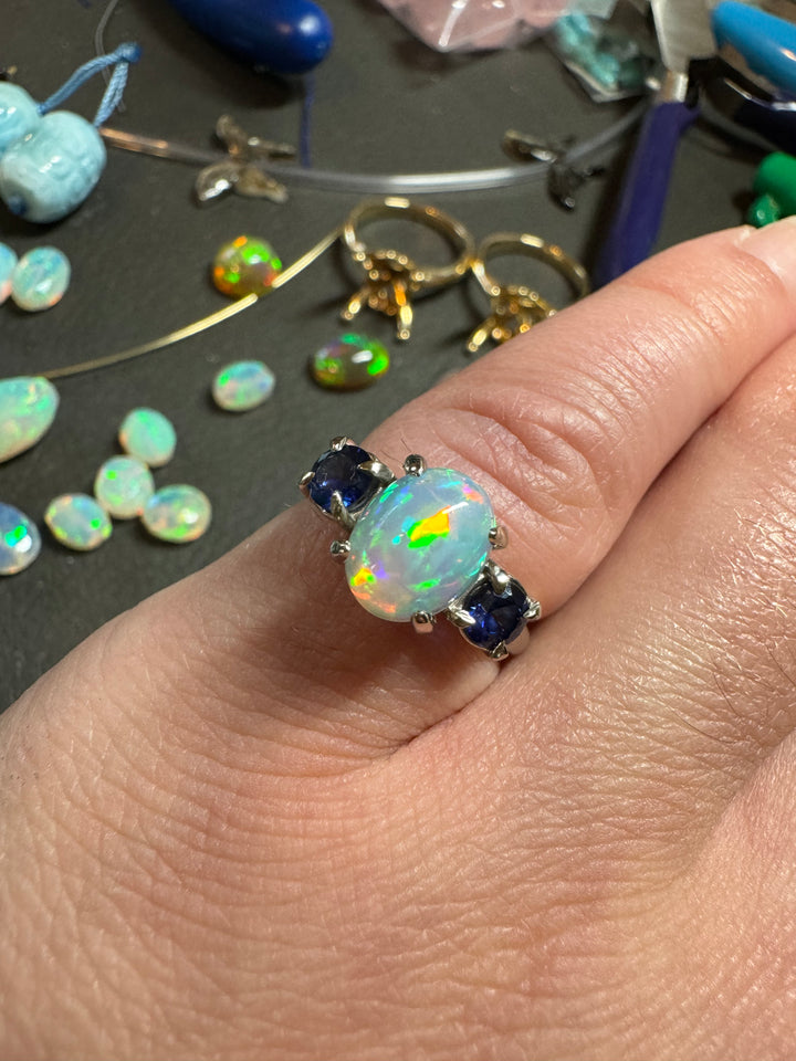 Custom opal ring with blue sapphires, profile view showing setting detail