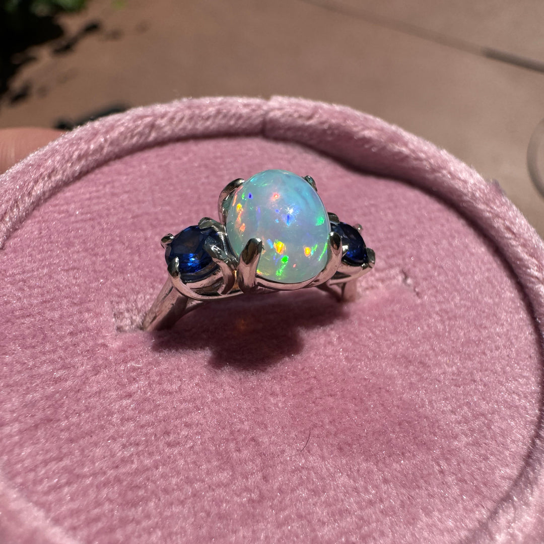 Side view of custom opal and blue sapphire ring in 14K white gold setting