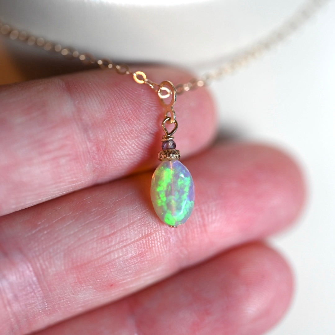 Vibrant green flash dark opal charm pendant in 14K gold with gray spinel accent