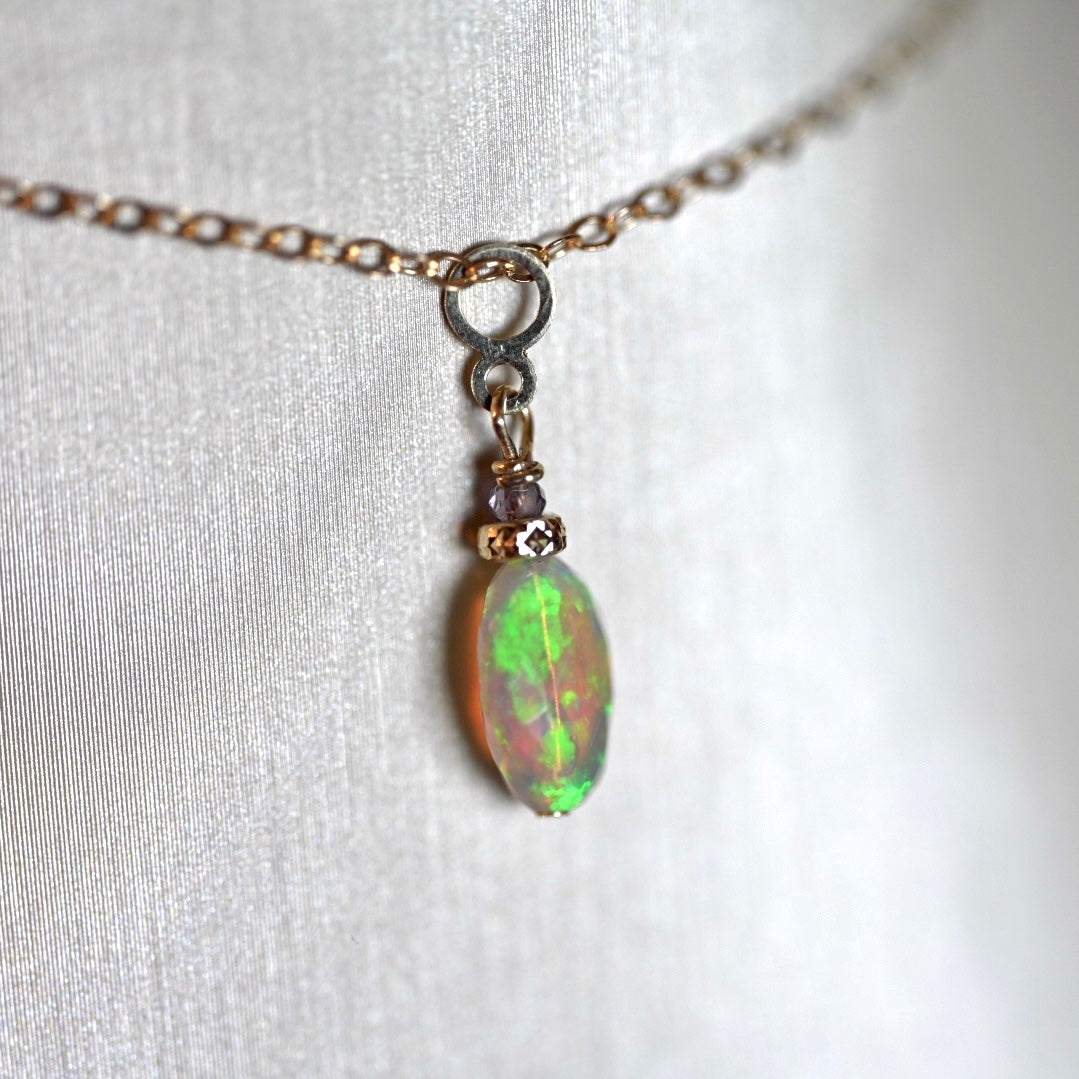 Close-up of natural Ethiopian opal with vibrant green and blue flash in 14K gold
