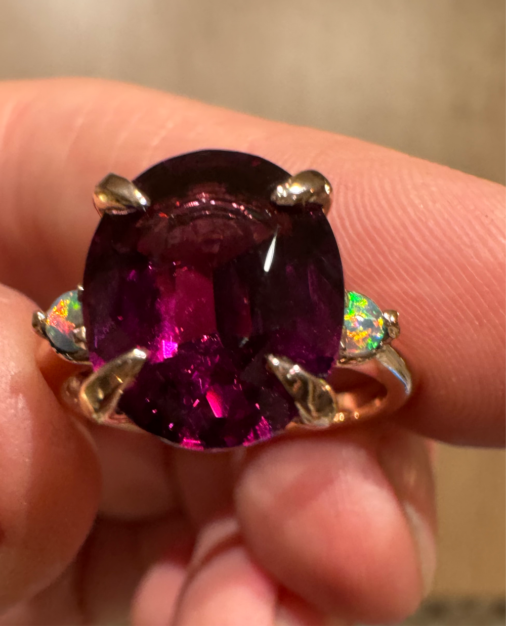 Unique three stone gemstone ring featuring natural purple umbalite garnet and red flash Australian opals