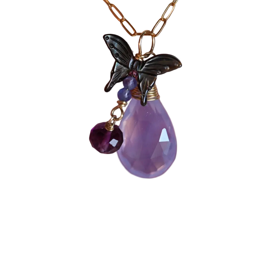 Purple teardrop pendant with a butterfly charm held in a hand against a neutral background.

Lavender quartz necklace with black mother of pearl butterfly and a dark purple fluorite set in 14k solid yellow gold. Beautiful nature inspired necklace. Butterfly jewelry, purple jewelry. Purple pendant. Opalora jewelry. Black hills jewelry. Handmade jewelry. 