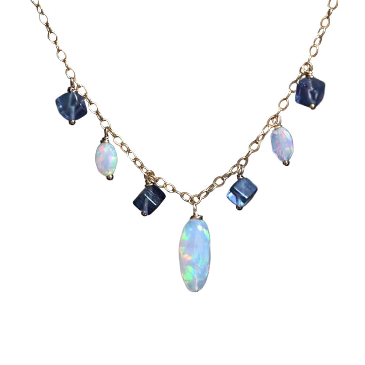 Necklace with opal and blue gemstones on a white background. Handcrafted white opal and purple fluorite beaded necklace by OpalOra with adjustable 18 inch chain.