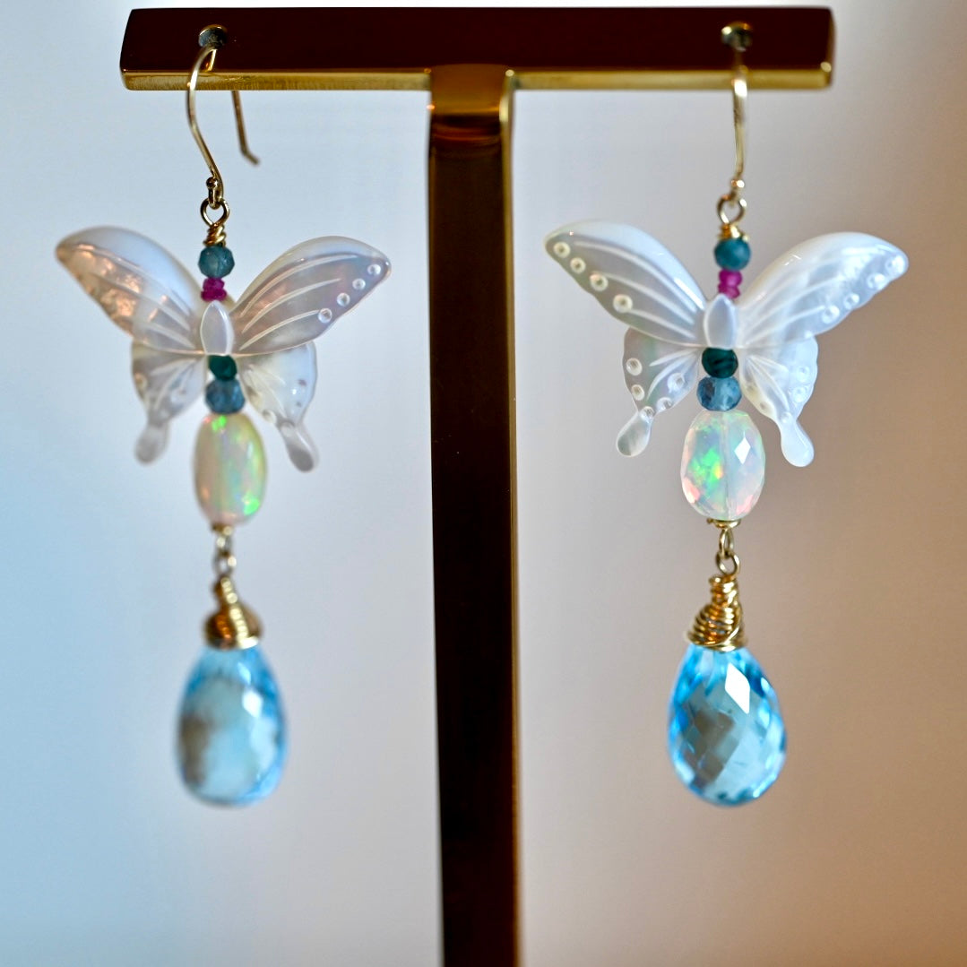Butterfly symbolism. Butterfly jewelry. Butterfly in 14k gold. 14k Gold earrings. 

Opal, Swiss Blue topaz briolette drops, Mother of Pearl butterfly Earrings in 14K solid Gold. Handmade earrings by opalora jewelry. Long butterfly earrings, gold earrings.