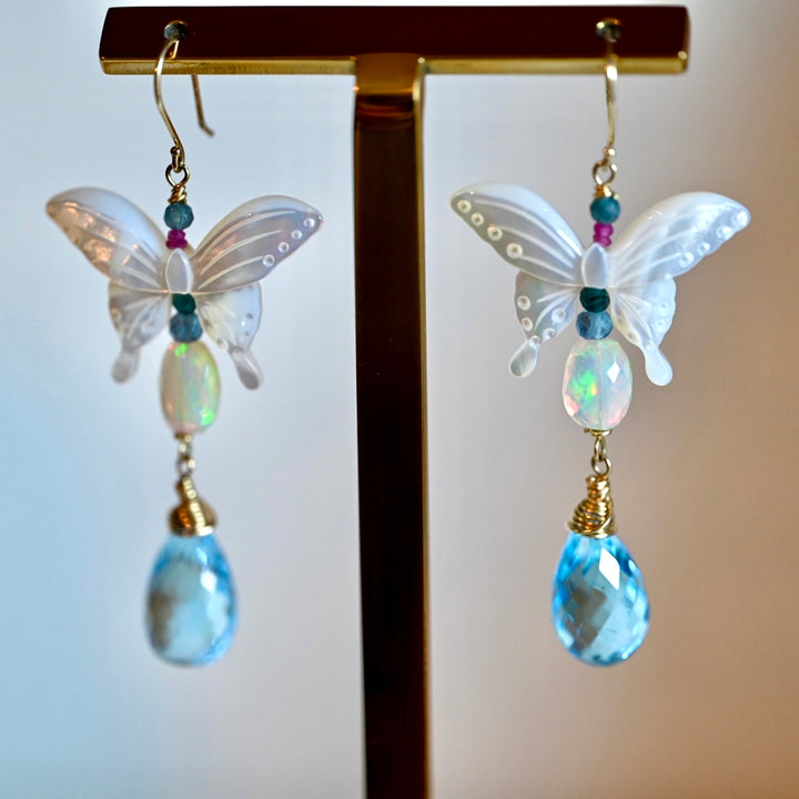 Butterfly symbolism. Butterfly jewelry. Butterfly in 14k gold. 14k Gold earrings. 

Opal, Swiss Blue topaz briolette drops, Mother of Pearl butterfly Earrings in 14K solid Gold. Handmade earrings by opalora jewelry. Long butterfly earrings, gold earrings.