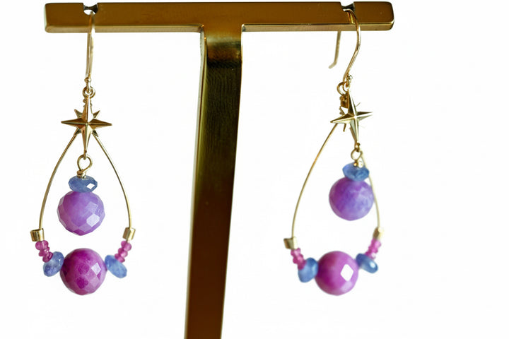 Ruby star earrings worn on model showing 2 inch dangle length with solid 14K gold stars