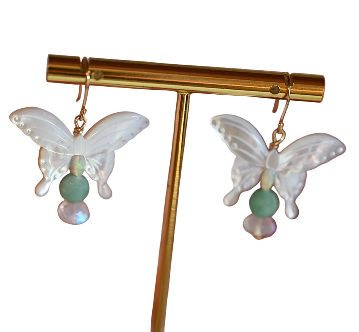 Get ready to flutter away with our exquisite 14K gold earrings featuring natural emeralds, opals, and moonstones in delicate butterfly shapes.

These beauties dangle at a length of 1 1/2 inches, perfect for adding a touch of whimsy to any outfit.